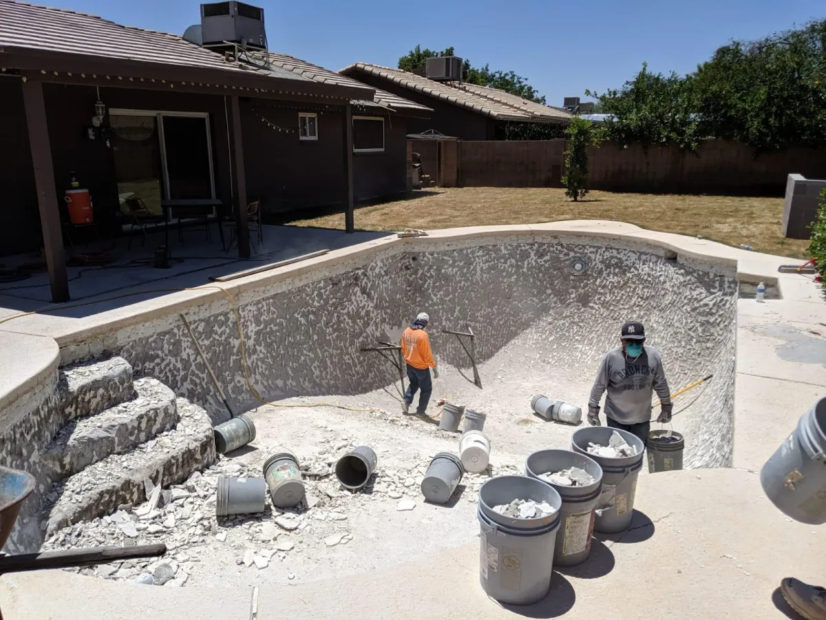 Crew removing the worn interior surface during pool preparation