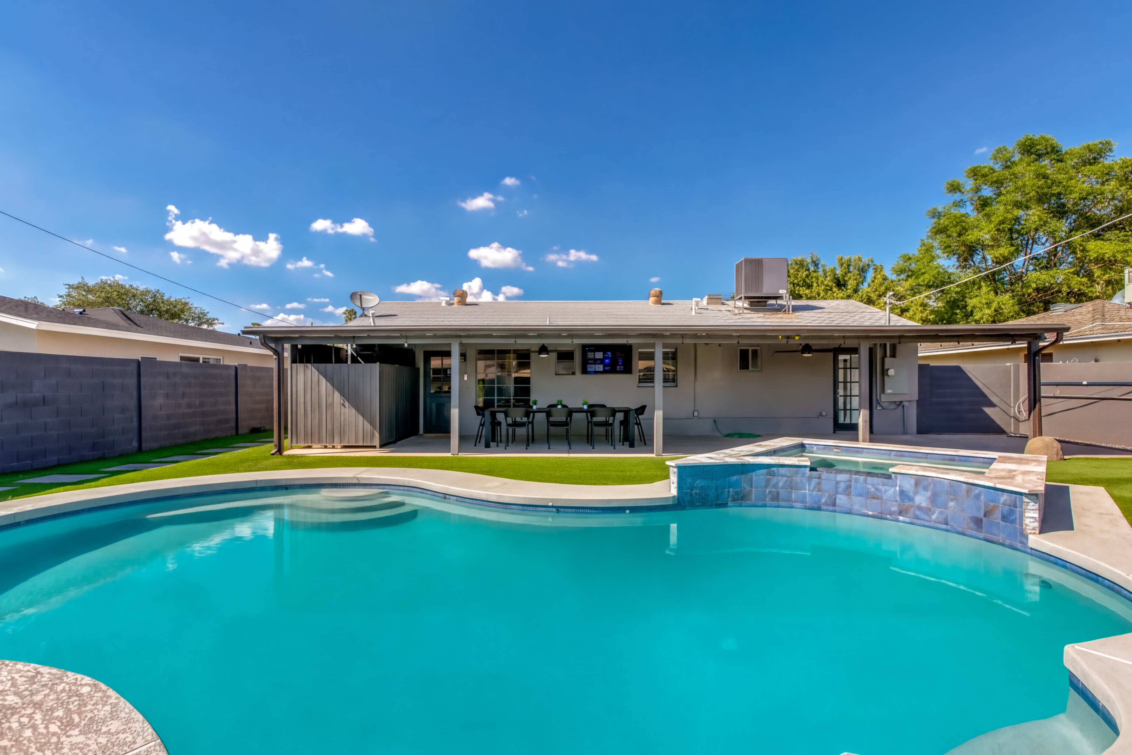 Filled pool and raised spa viewed toward the covered patio and dining area