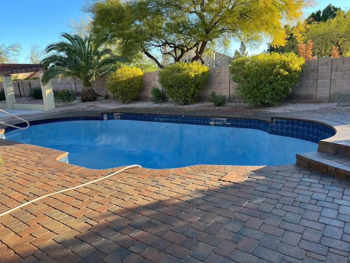 Freeform existing pool after a finished blue interior, new waterline tile, and paver deck